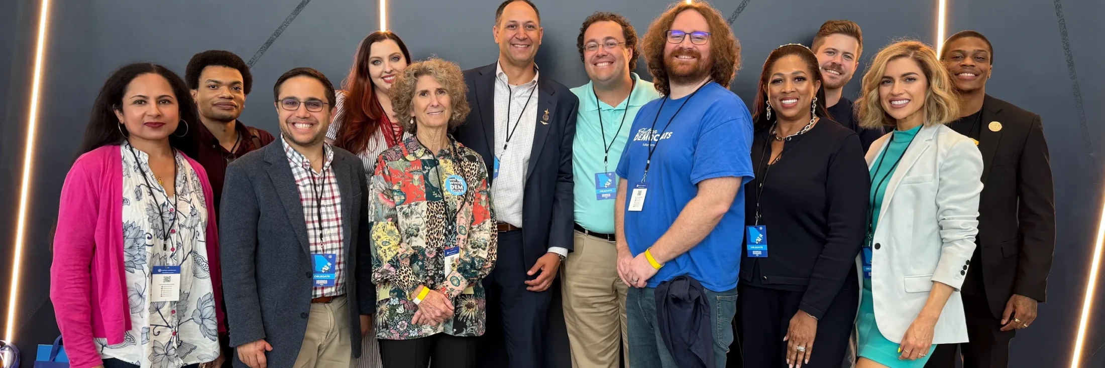 Thirteen Fulton County Democrats standing together for a group photograph at the 2026 Georgia Democratic convention, wearing delegate badges.