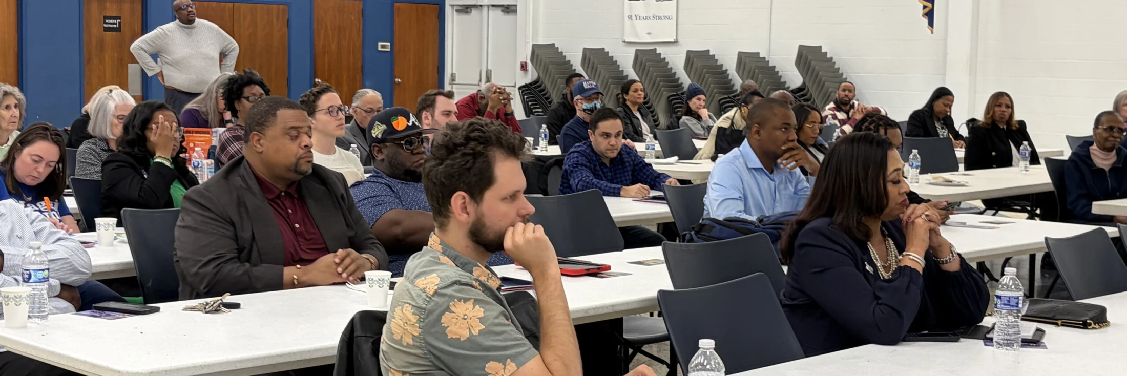 Members of the Fulton County Democrats seated at tables through a county committee meeting, listening to a speaker.